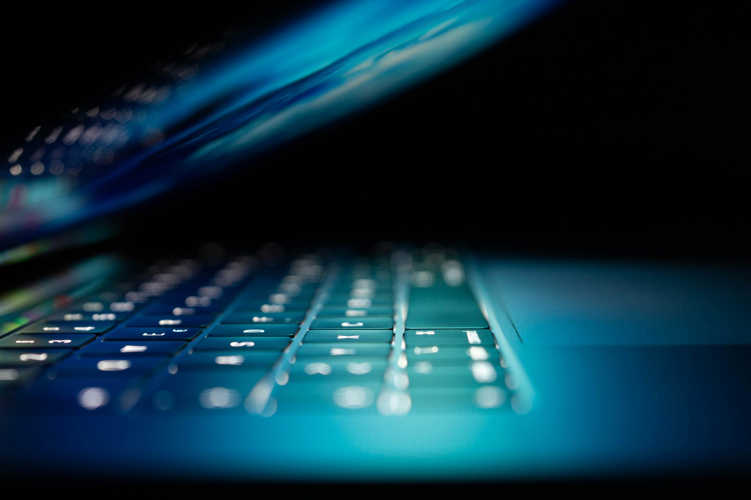 laptop screen closing on dark background